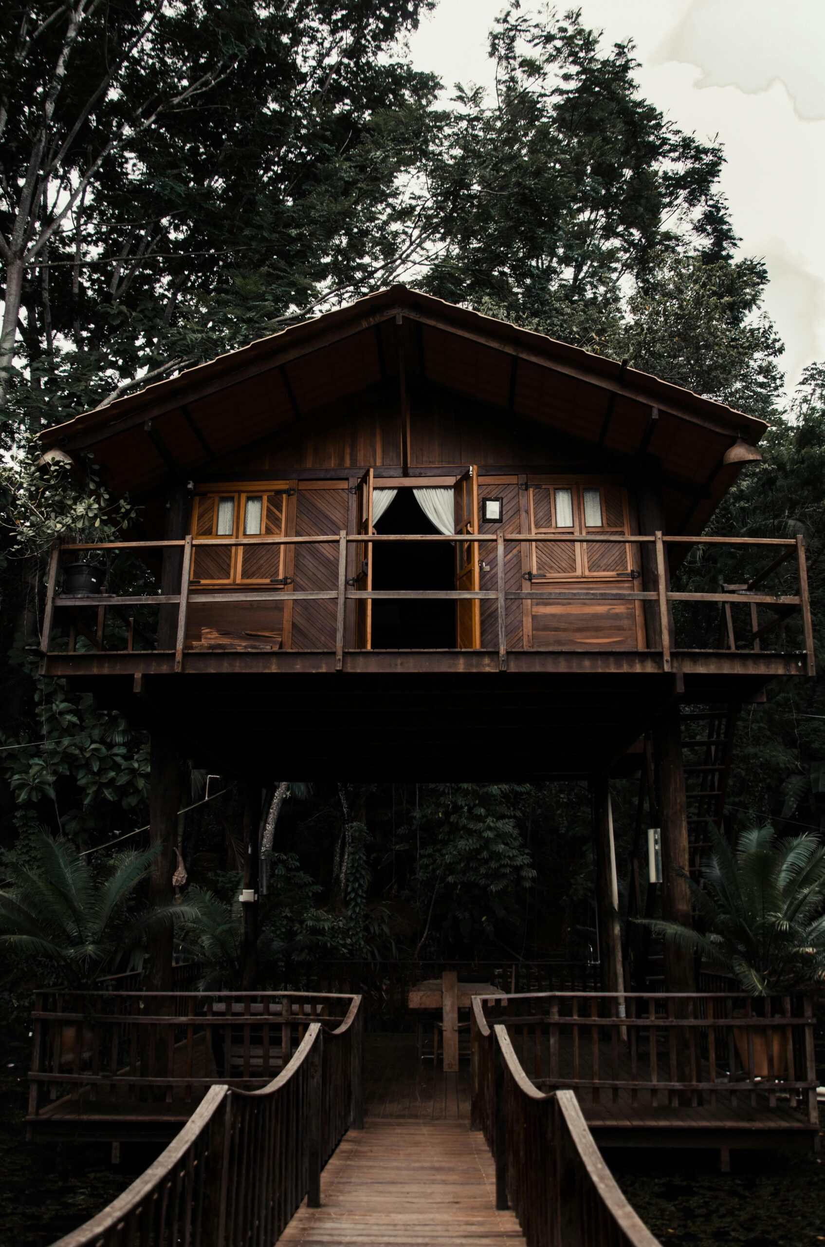 A cozy wooden treehouse nestled among lush forest greenery, perfect for a nature getaway.